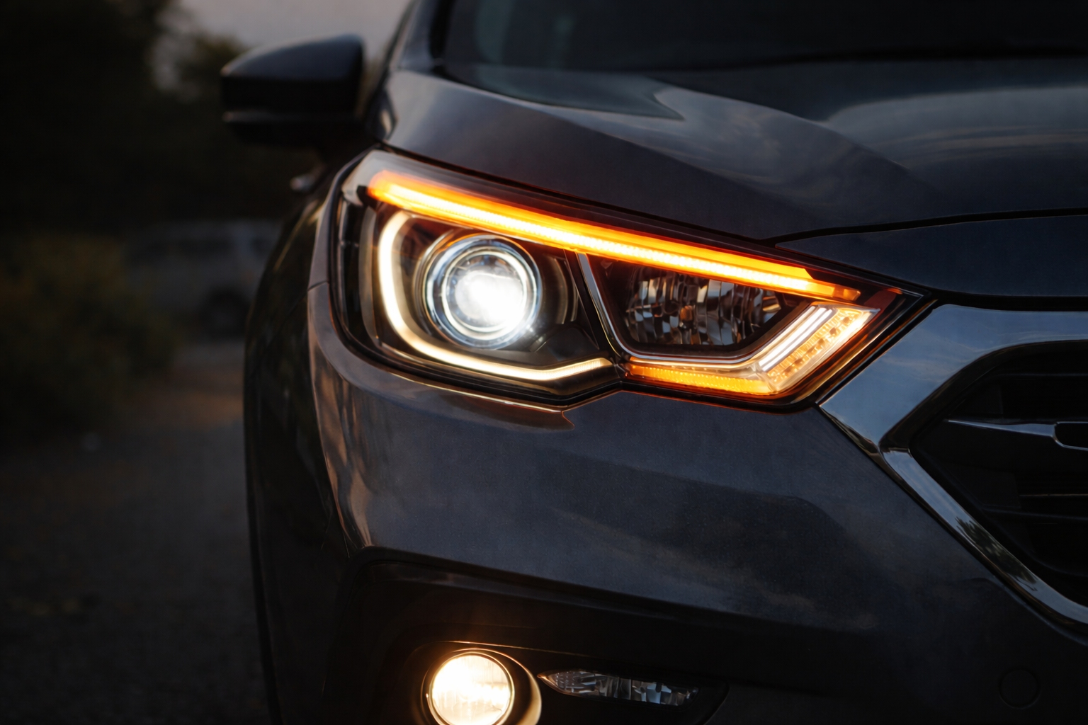 Close-up of LED projector headlights on a car showing focused beam pattern and integrated DRL strip for improved night visibility